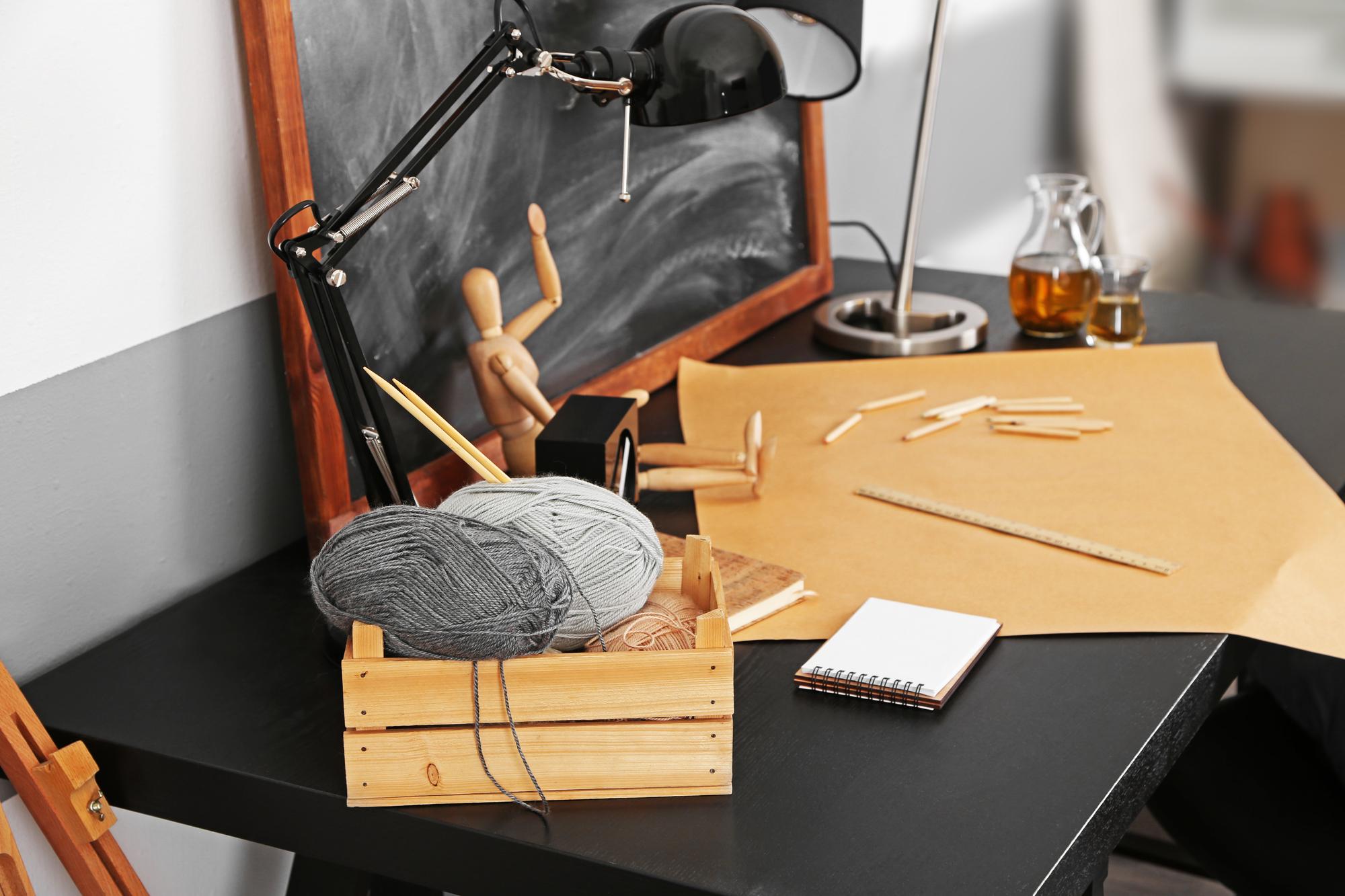 Tavolo da lavoro con fili, telai e schizzi di design